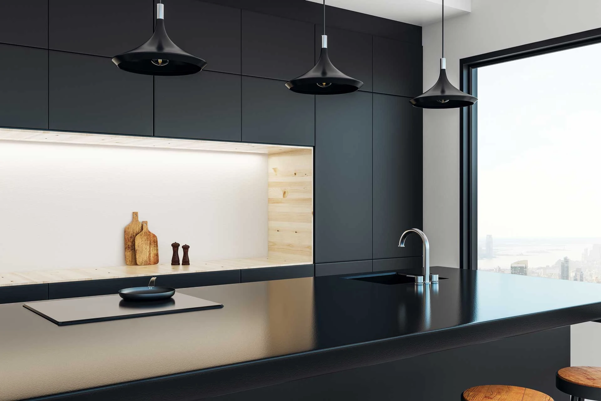 A kitchen with a black counter top next to a window.